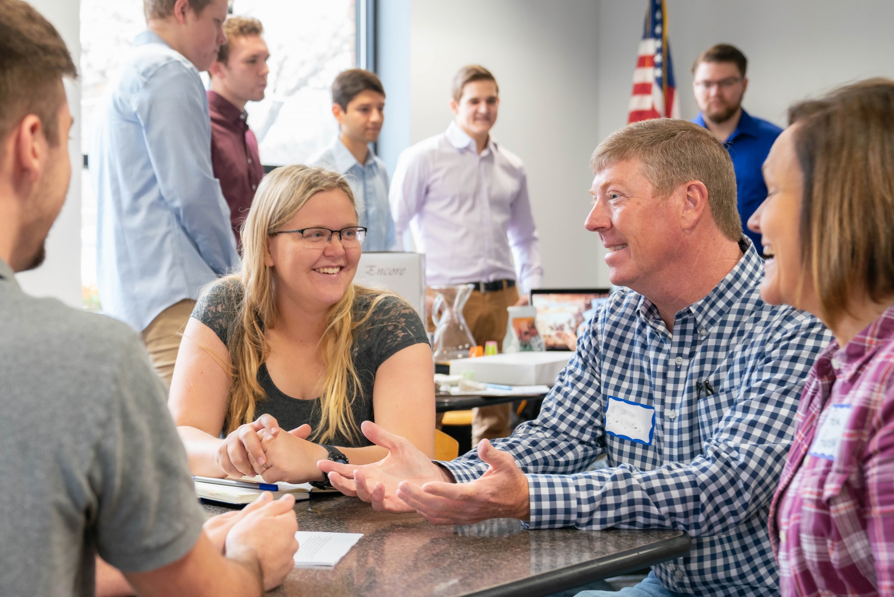 Students and community members talk around a table